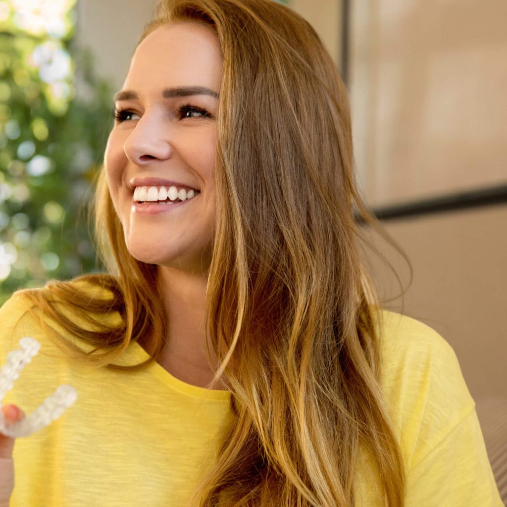 Lächelnde Person mit Invisalign Vivera Retainer