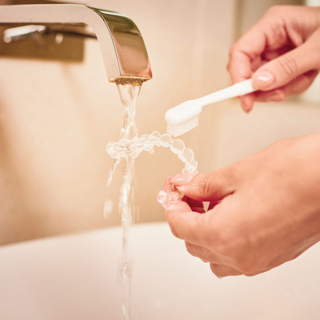Junge Frau trägt Invisalign-Aligner im Alltag